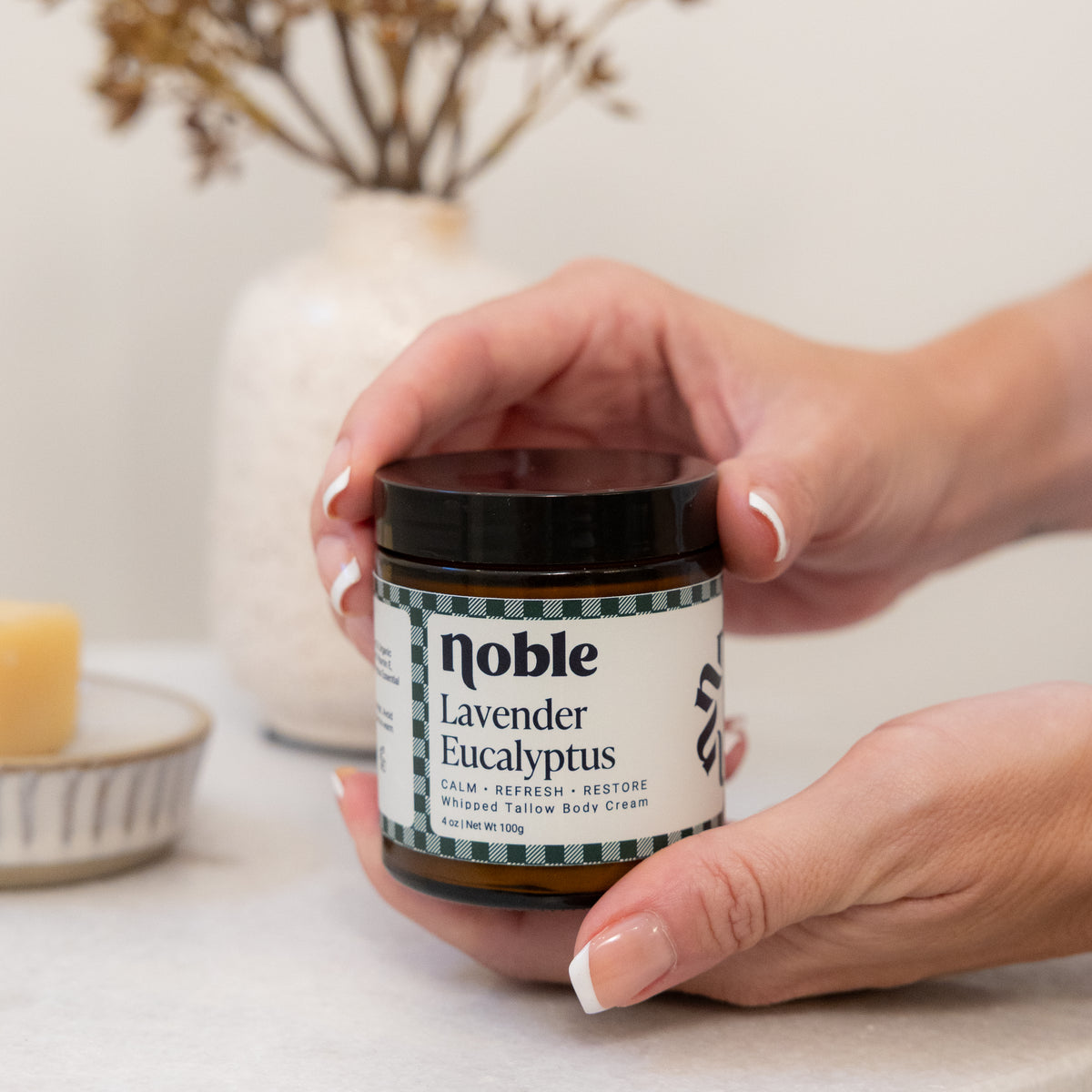 Hands holding a Lavender Eucalyptus Body Tallow jar.