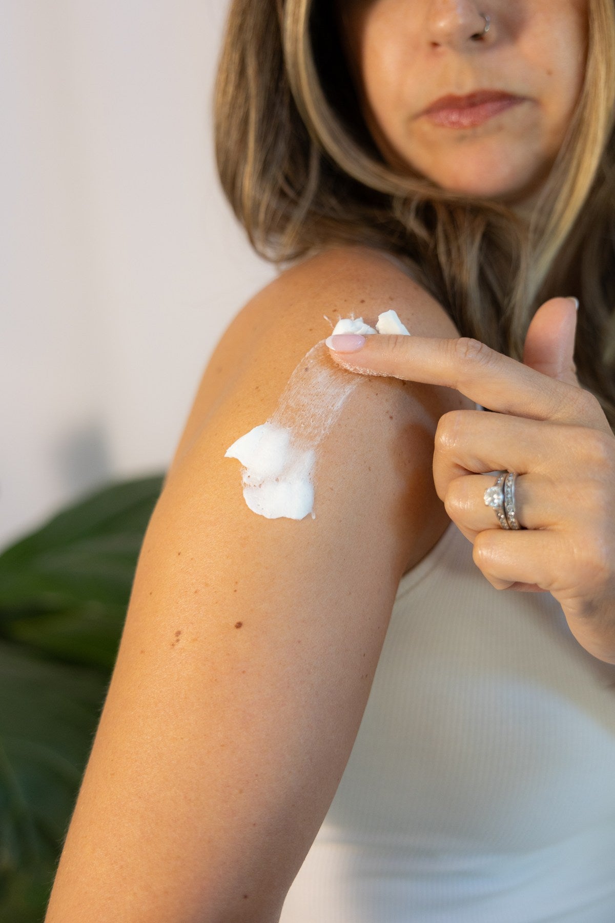 A woman smoothing body tallow over her upper arm.