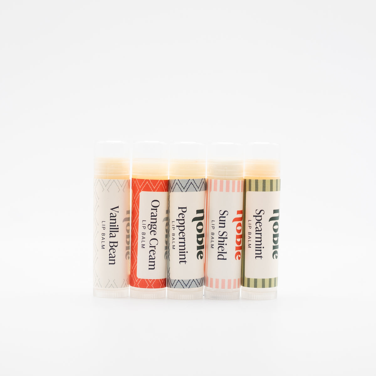 Five Noble Tallow Lip Balm sticks with scent labels facing forward.