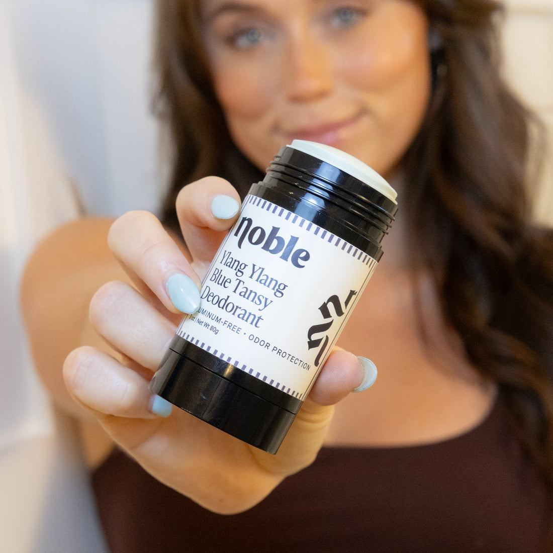 Person holding an open Ylang Ylang Blue Tansy Deodorant stick.