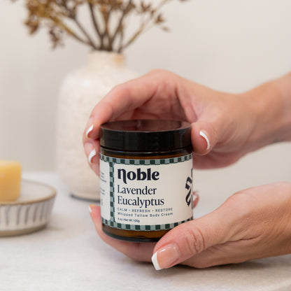 Hands holding a Lavender Eucalyptus Body Tallow jar.