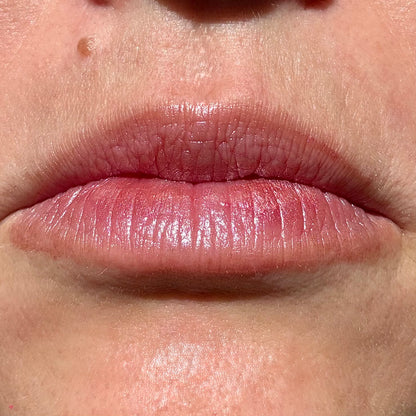 Close-up of lips wearing Mauve Mist tinted lip balm by Noble Skin Co., a soft plum-rose shade with a subtle natural sheen