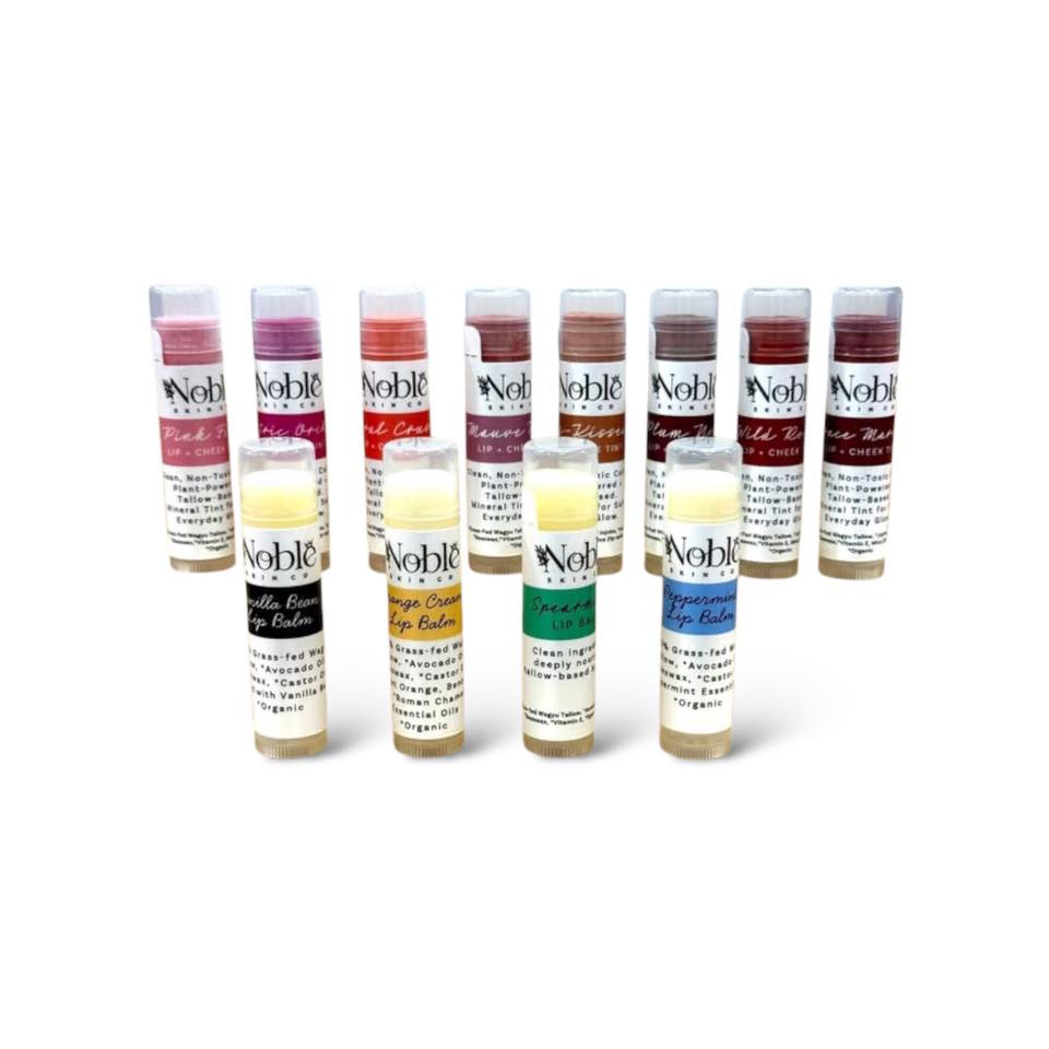 Collection of Noble Skin Co. lip balms and tinted cheek stains made with grass-fed tallow, displayed on a white background