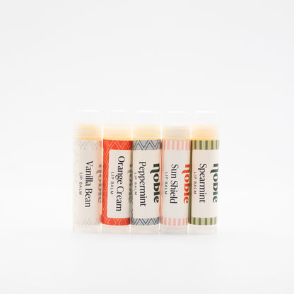 Five Noble Tallow Lip Balm sticks with scent labels facing forward.