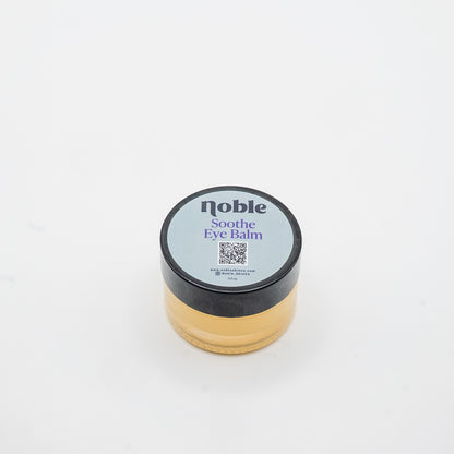 Noble Skin Co. Soothe Eye Balm 0.5 oz clear glass jar with labeled black lid
