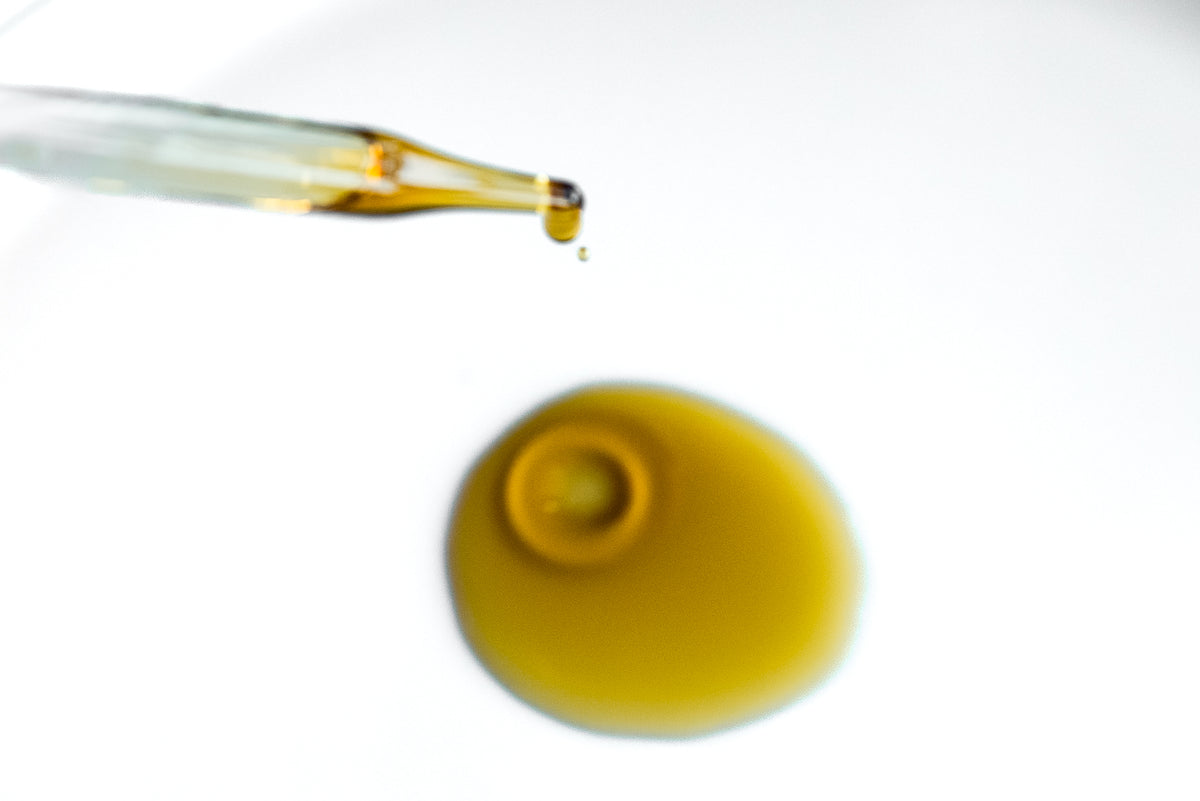 Cleansing Oil dropper above a golden pool of oil.