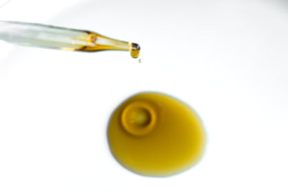 Cleansing Oil dropper above a golden pool of oil.