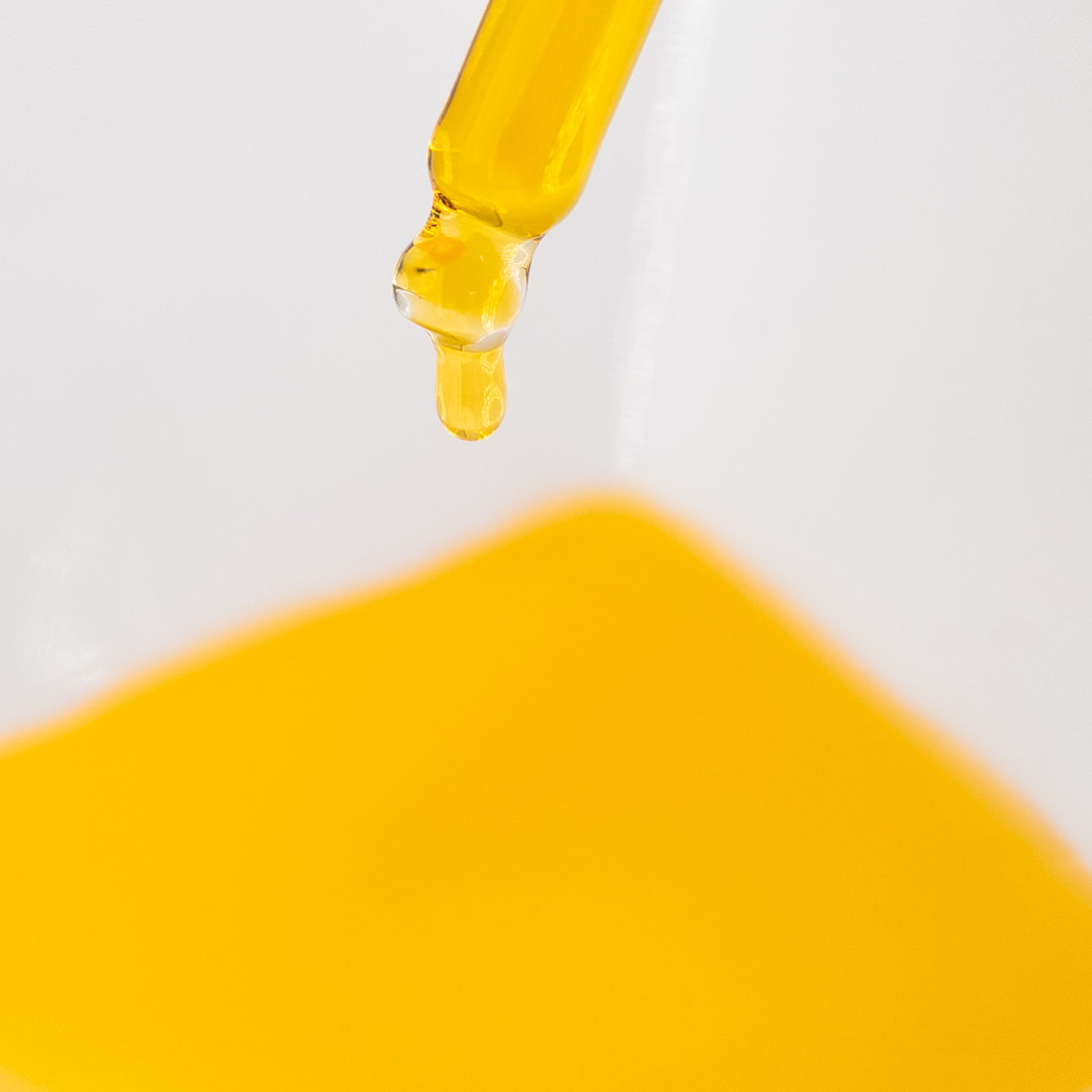 Golden Rejuvenate Face Serum beneath a glass dropper.