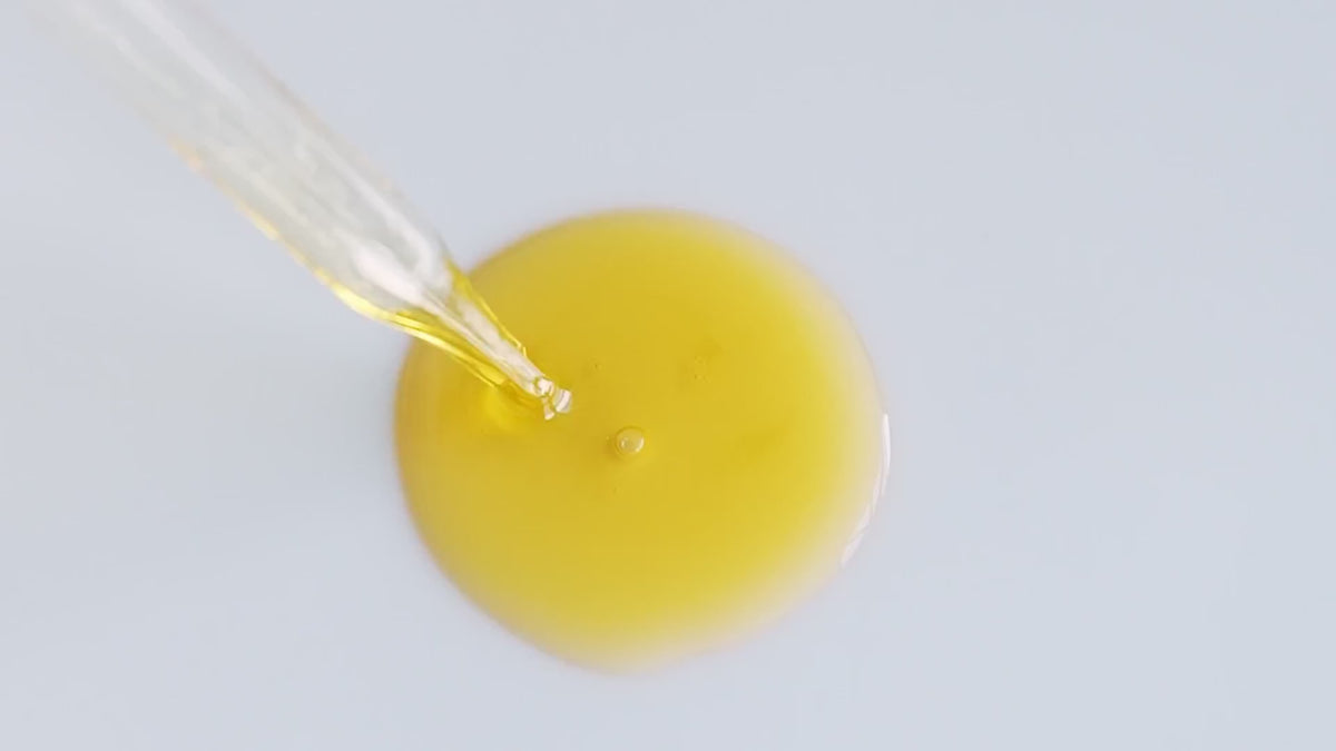 Golden Hour Serum pool beneath a glass dropper.