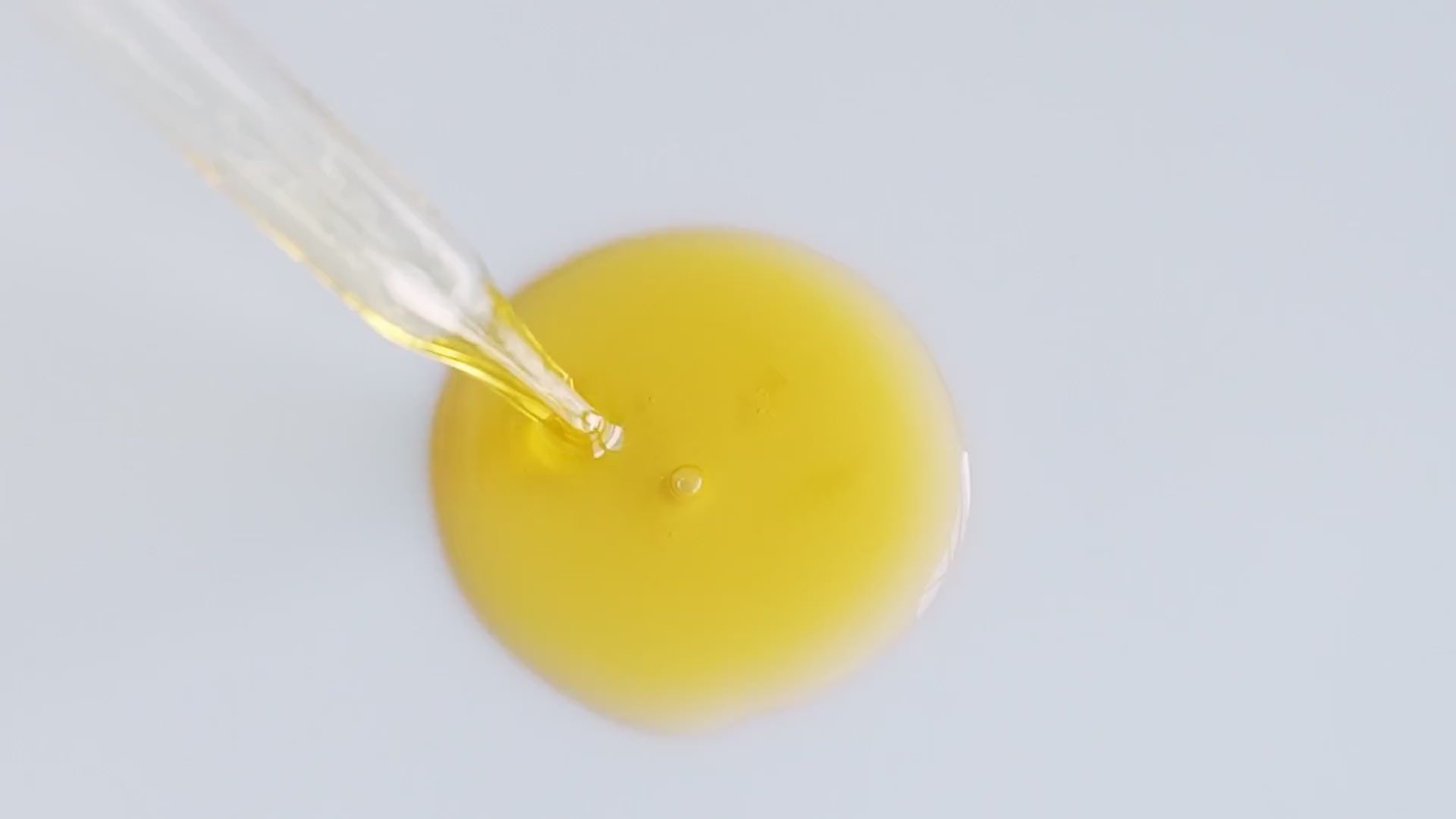 Golden Hour Serum pool beneath a glass dropper.