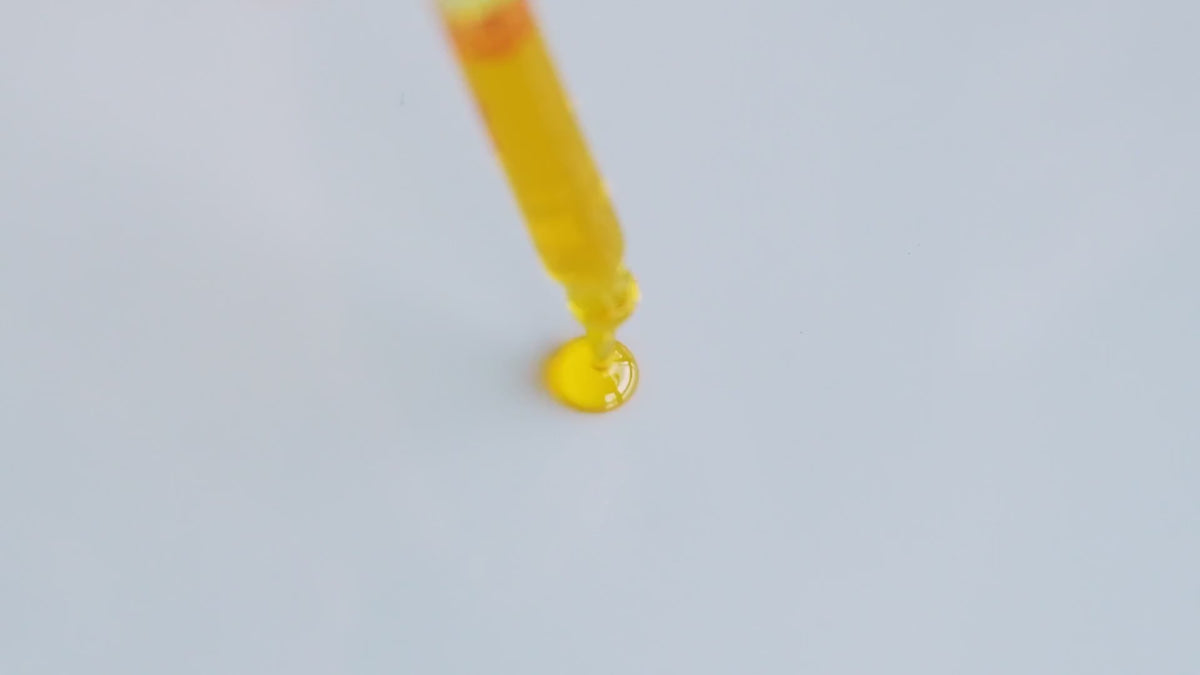 Golden Glow Up Serum poured from a dropper.
