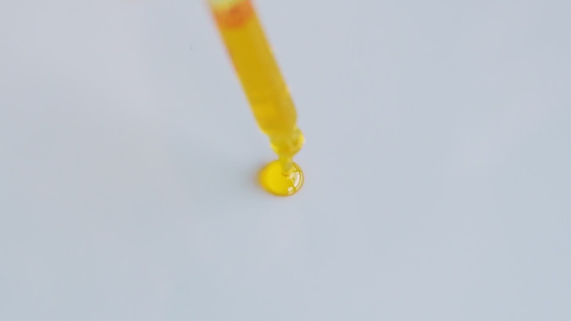 Golden Glow Up Serum poured from a dropper.