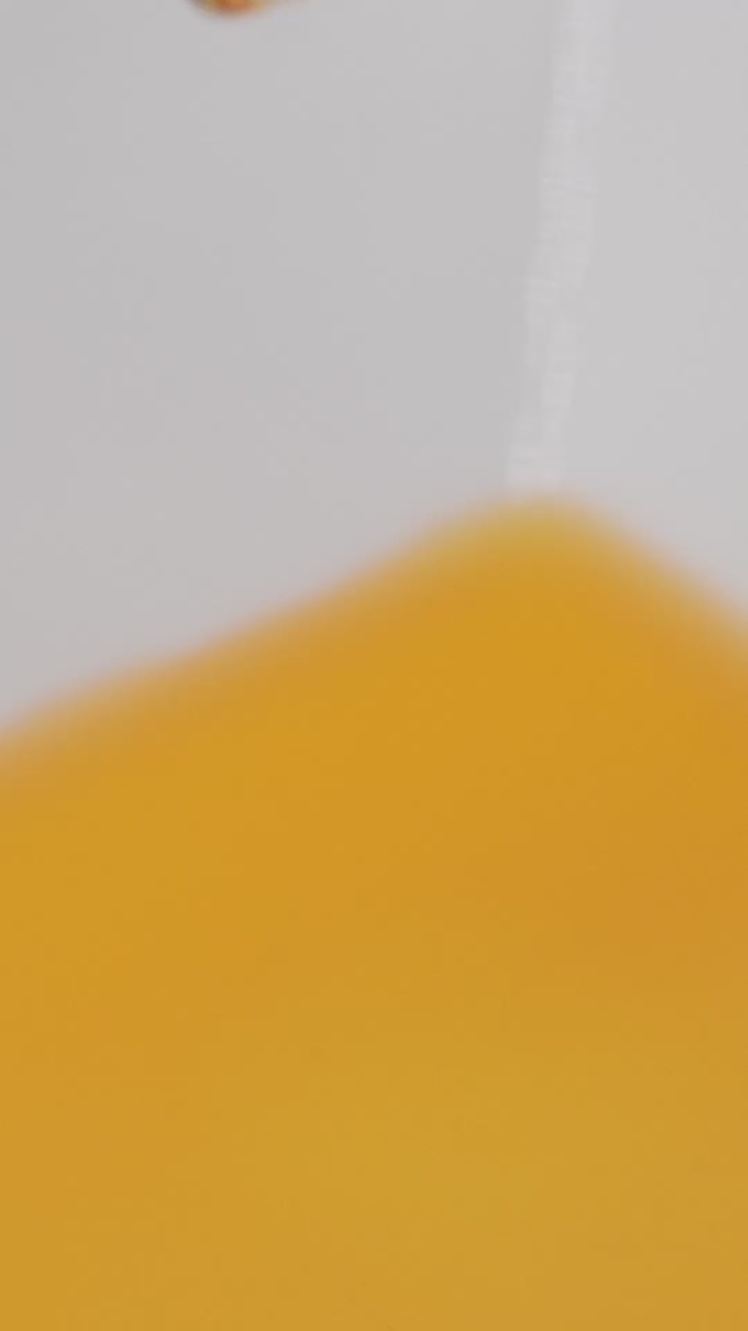 Close-up of golden Rejuvenate Face Serum texture in motion.
